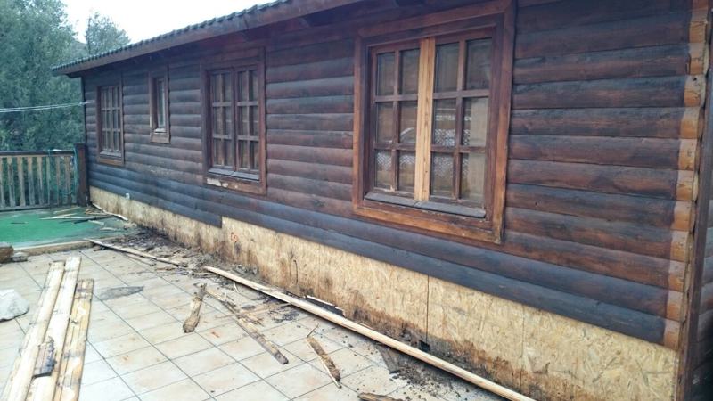 base de la casa de madera expuesta a la humedad